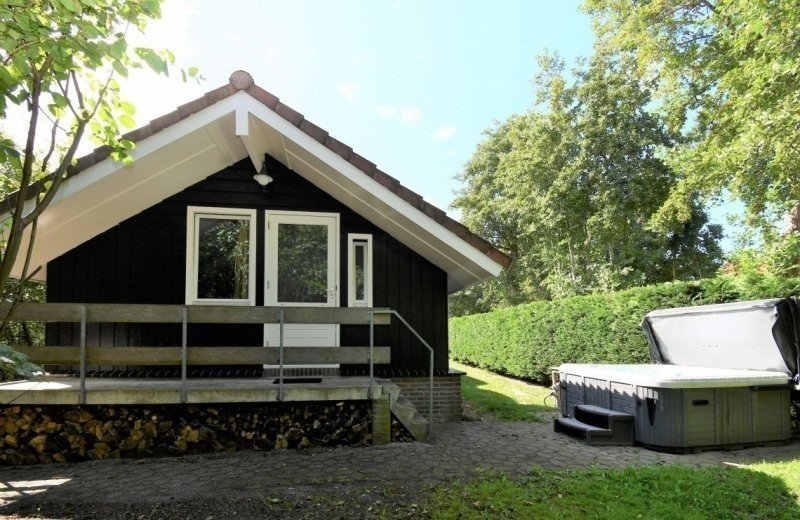 Buitenkant accomodatie met een buitenspa jacuzzi